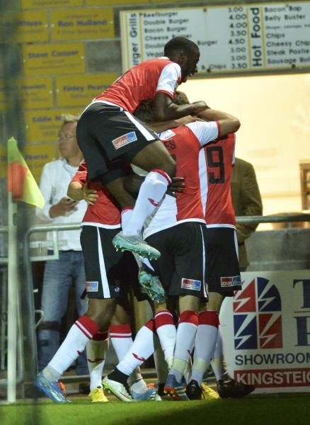 Devon Cream: Ismail Yakubu is mobbed by his team-mates as he tries to sneak off for a burger after his late winner at Torquay (Photo: David Holmes)