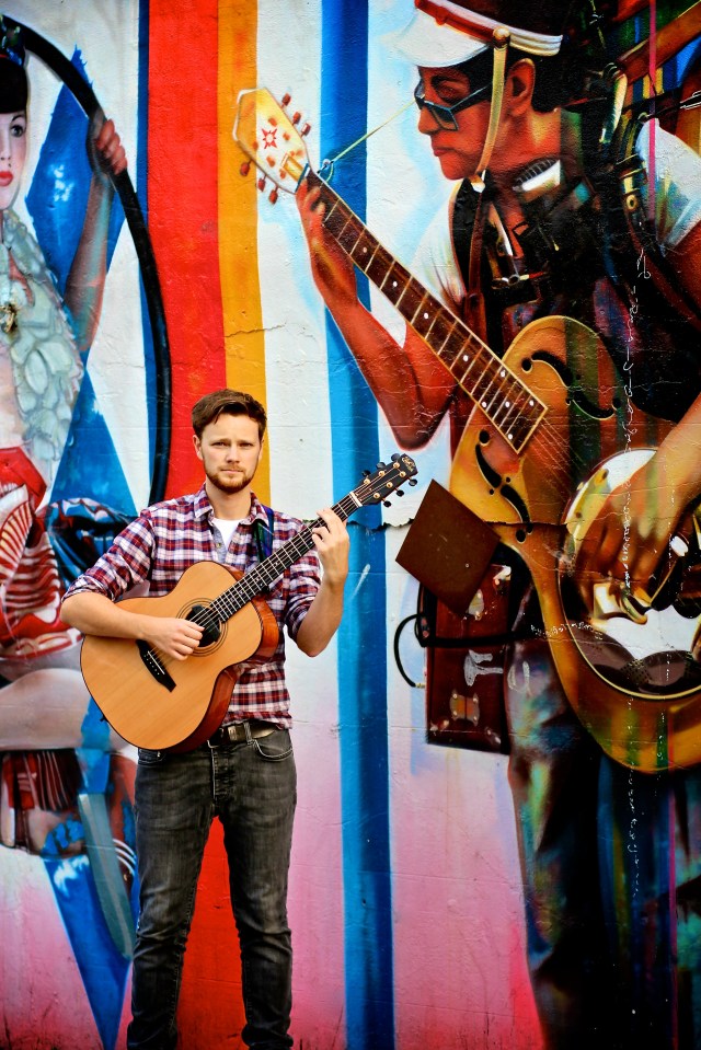 Duelling Guitars: Elliott Morris in good company by Brazilian artist Eduardo Kobra's street mural on the back wall of The Roundhouse, Chalk Farm (Photo copyright: Vanessa Haines Photography)